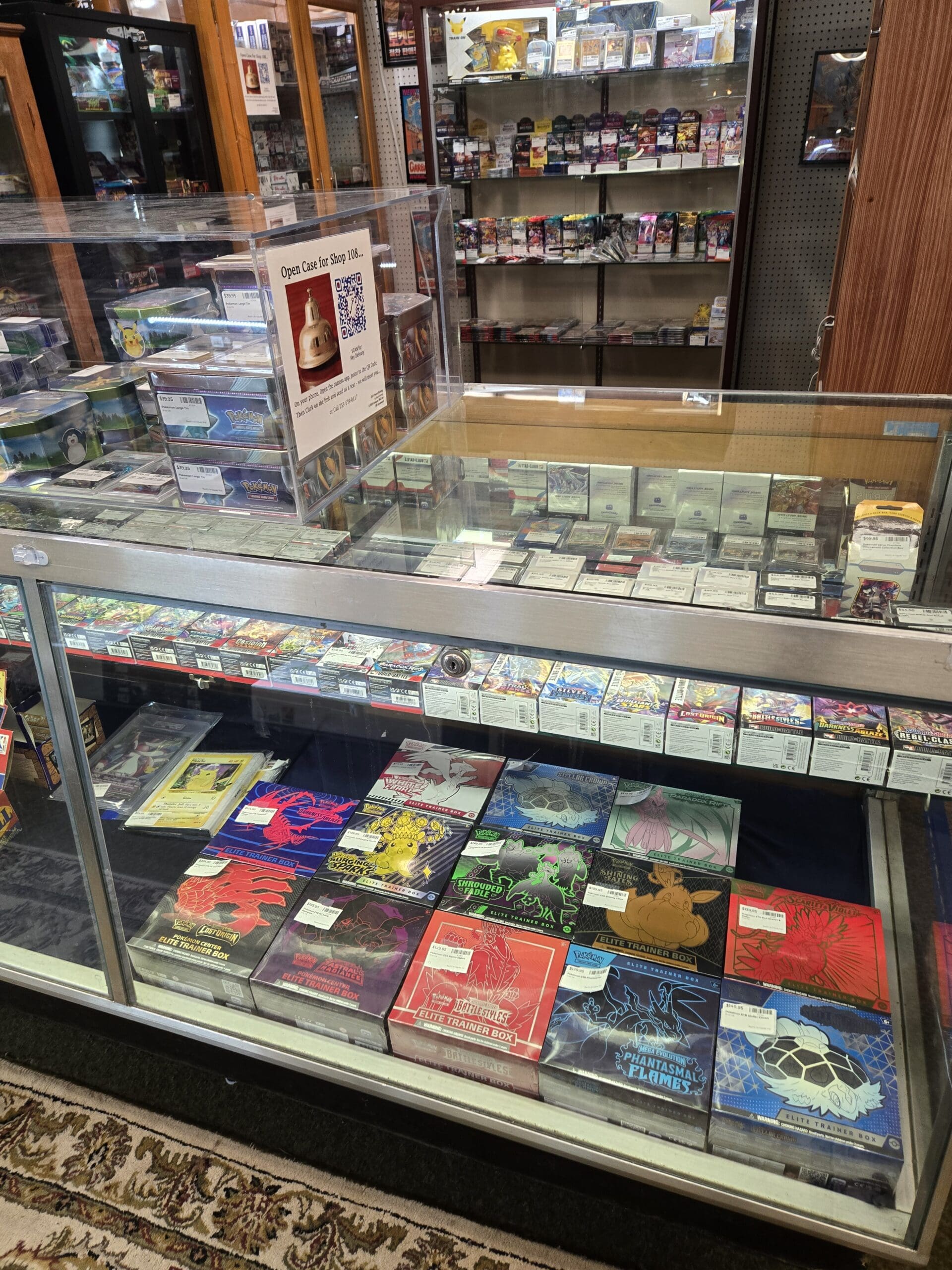 Sealed Pokémon TCG Elite Trainer Boxes including Shrouded Fable, Surging Sparks, Battle Styles, Phantasmal Flames, Lost Origin, Rebel Clash, and Silver Tempest, alongside sealed booster boxes, Pokémon Center exclusive products, PSA-graded slabs, and rows of sealed booster packs spanning multiple modern and vintage sets at Shop 108, Pacific Antiques Mall in Tacoma, WA.